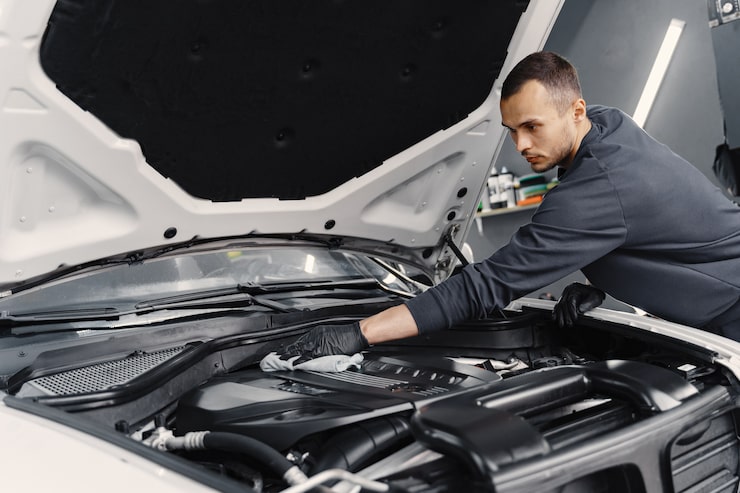 Mechanic examining car engine bay
